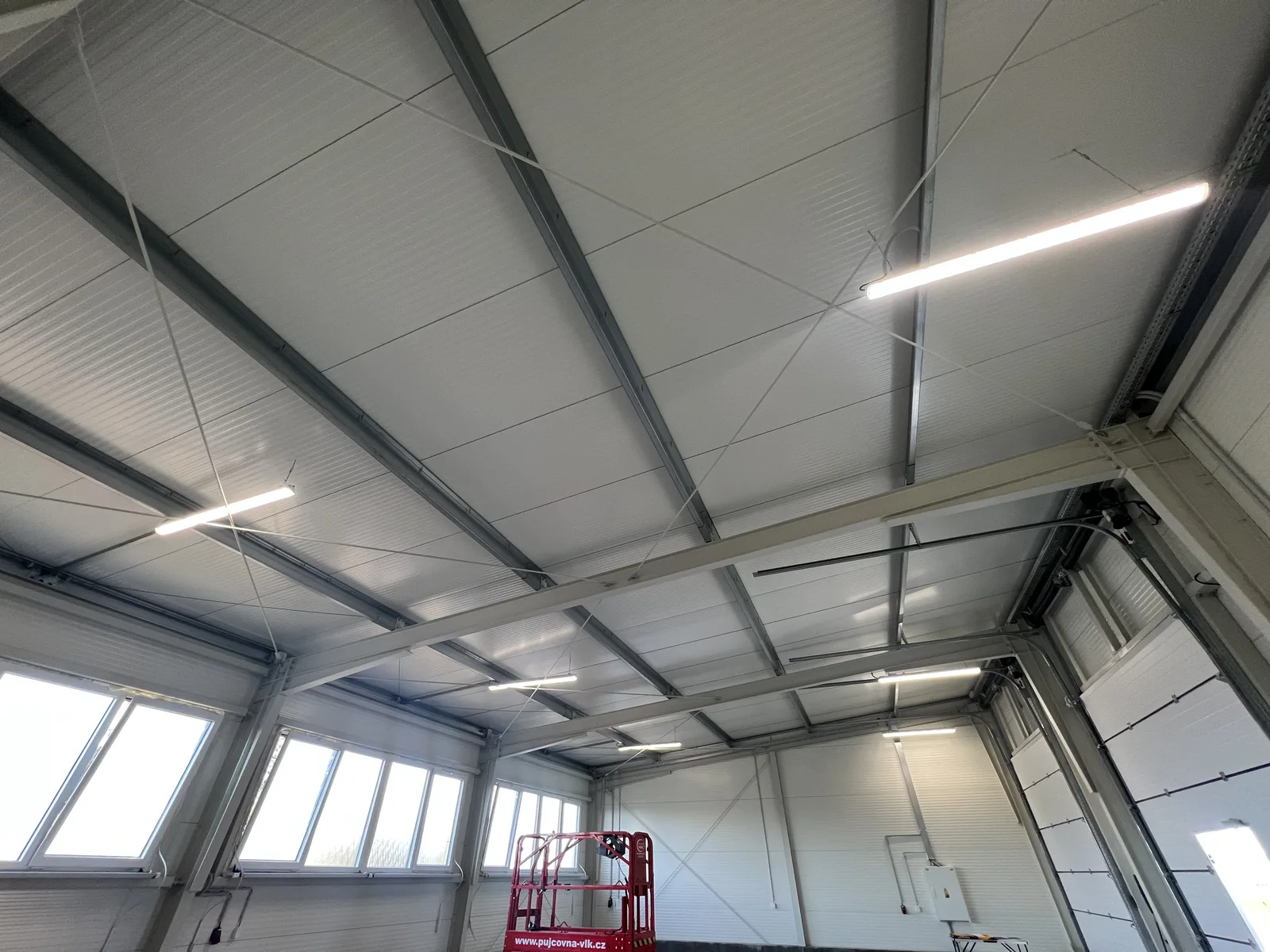 Detailed view of an industrial ceiling with steel structure and linear lighting