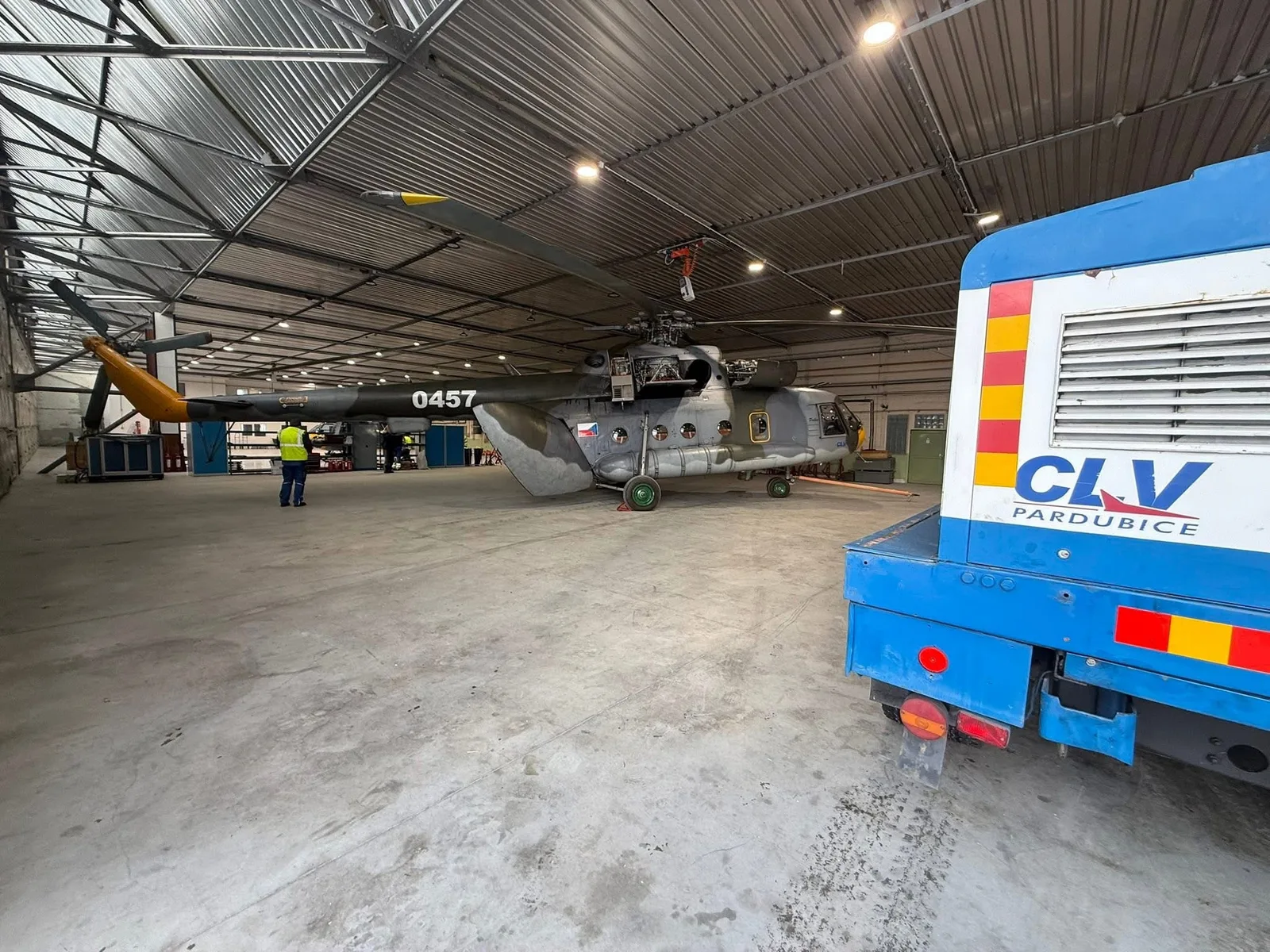 Helicopter inside a technically illuminated maintenance hangar
